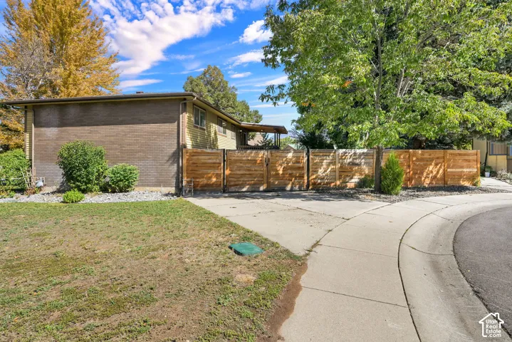 Mature trees and landscaping frame the property, fenced in yard, additional parking and access to backyard.