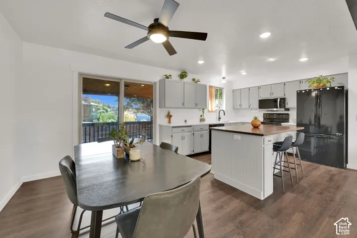 Open-concept kitchen and dining area featuring wood-finish flooring, recessed lighting, and a ceiling fan