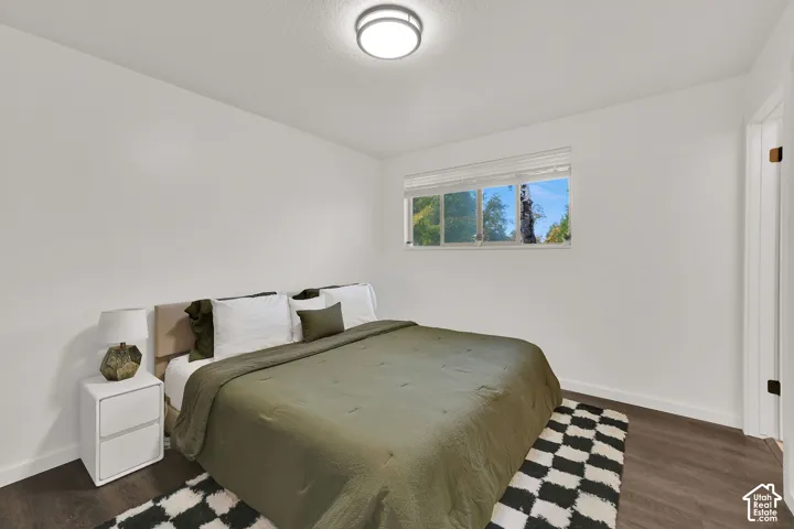 Main 3rd Bedroom with private bath. White walls, wood-finish flooring, and a flush mount ceiling light