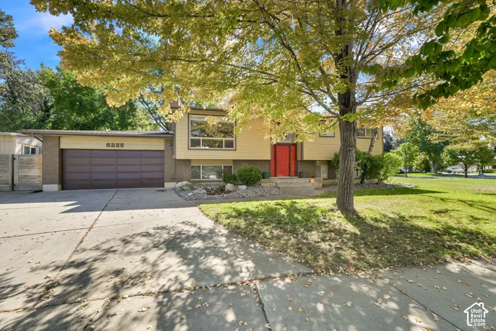 Split-level exterior featuring a red front door, large windows, and an integrated garage