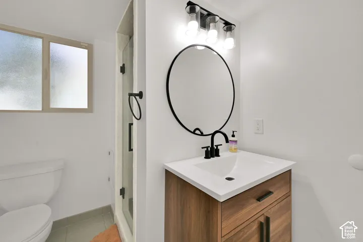 Vanity with wood-finish cabinetry, white countertop, and integrated sink