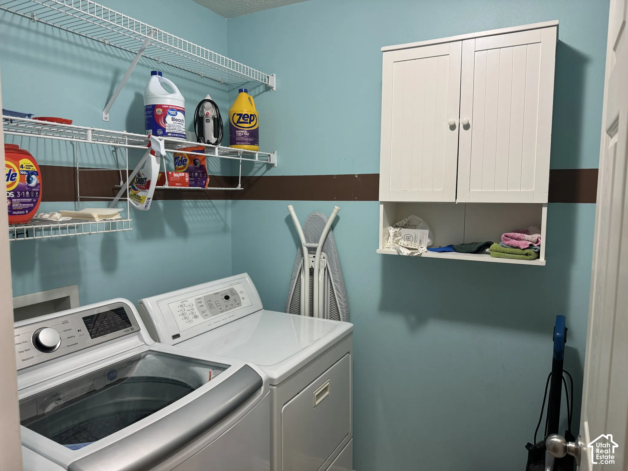 White wire shelving system, wall-mounted white cabinetry with enclosed storage, and a two-tone wall finish