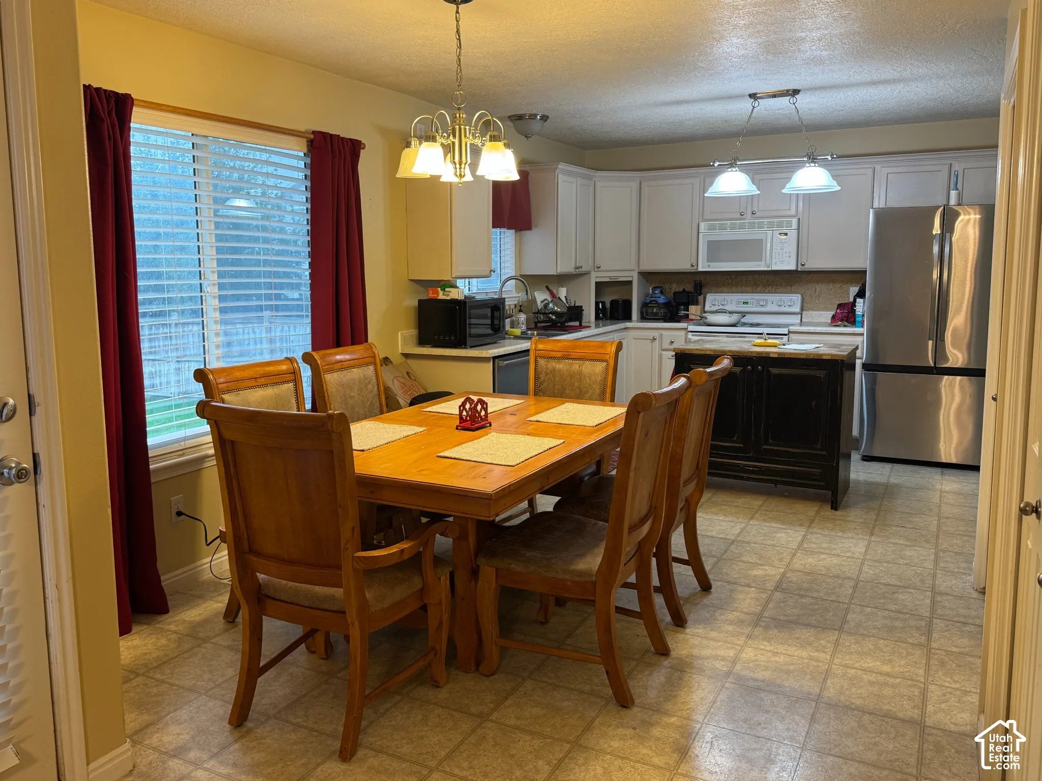 Open-concept dining area with tile flooring and a multi-light chandelier