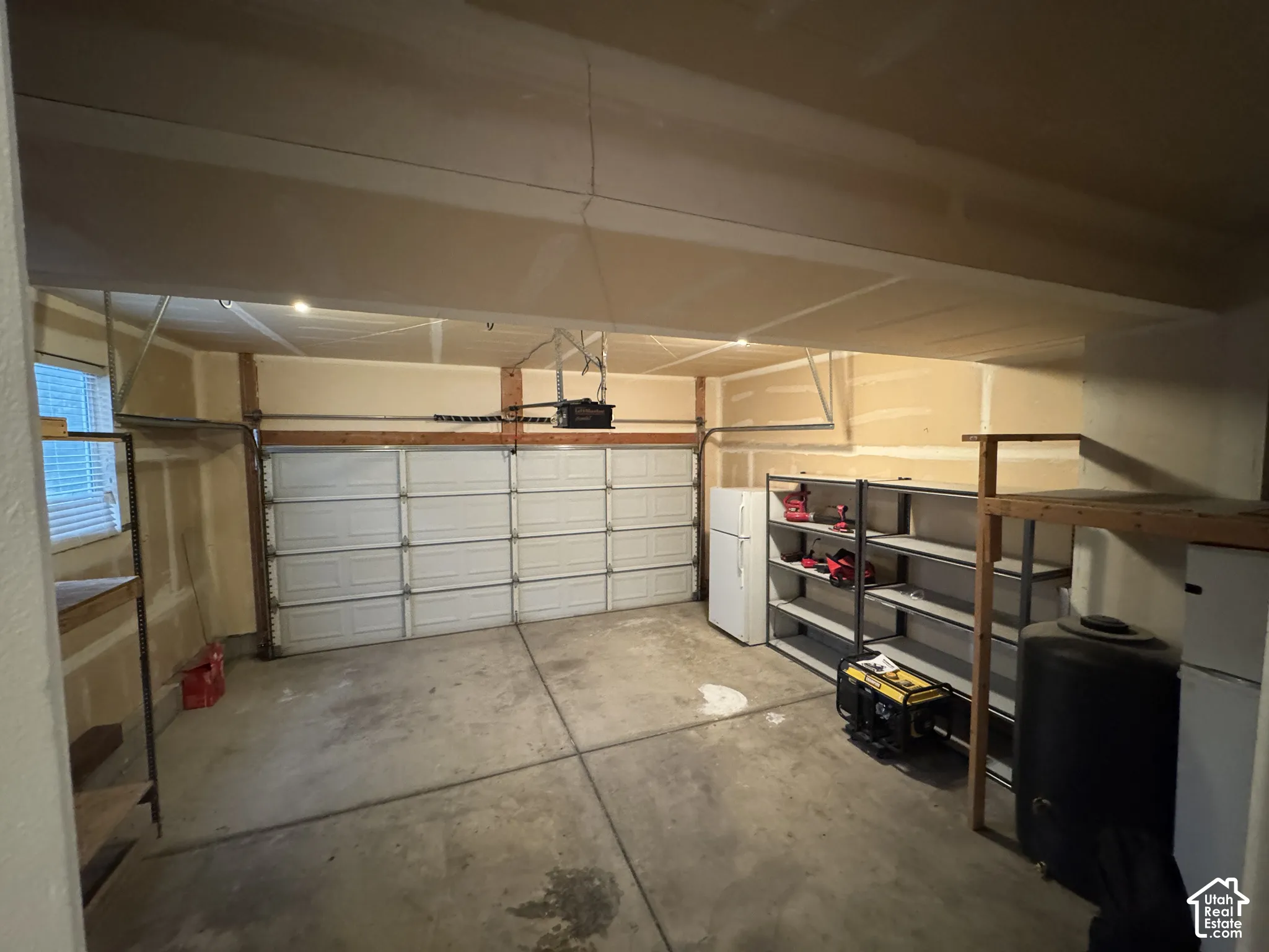 Two-car garage featuring a window, built-in shelving, and overhead lighting