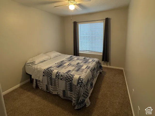Bedroom 2 Carpeted room featuring a ceiling fan with integrated lighting, window with blinds, and neutral wall tones