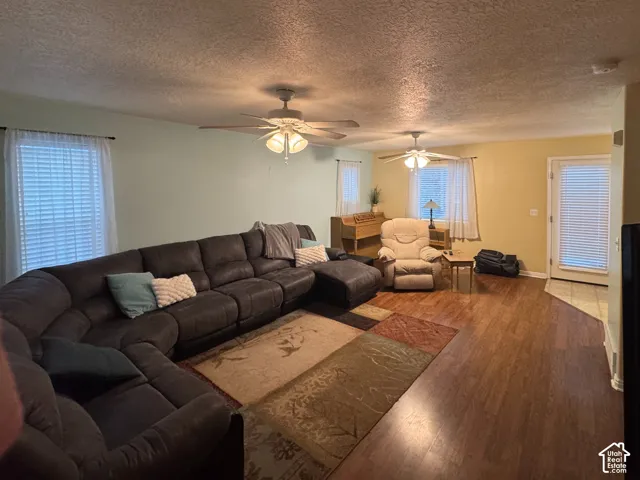 View 1 Wood-finish flooring, multiple windows with blinds, two ceiling fans, and a tiled entry