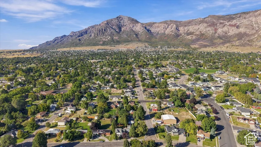 Expansive residential area with mature tree coverage, situated against a prominent mountain range