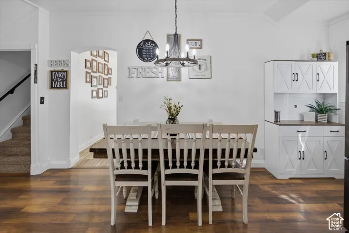 Wood-finish flooring throughout, with an arched entryway and white built-in cabinetry featuring X-detail doors and dark hardware