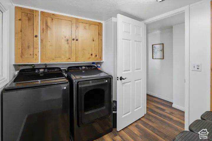 Wood-finish flooring, white paneled door, and natural wood cabinetry