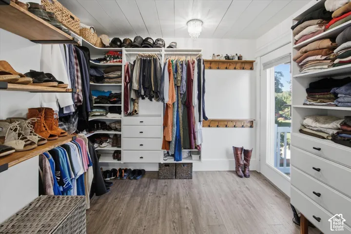 Custom closet system featuring wood-finish shelving, built-in drawers, and extensive hanging rods