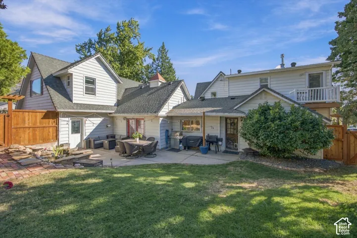 Expansive backyard featuring a concrete patio, brick paver accents, and a privacy fence