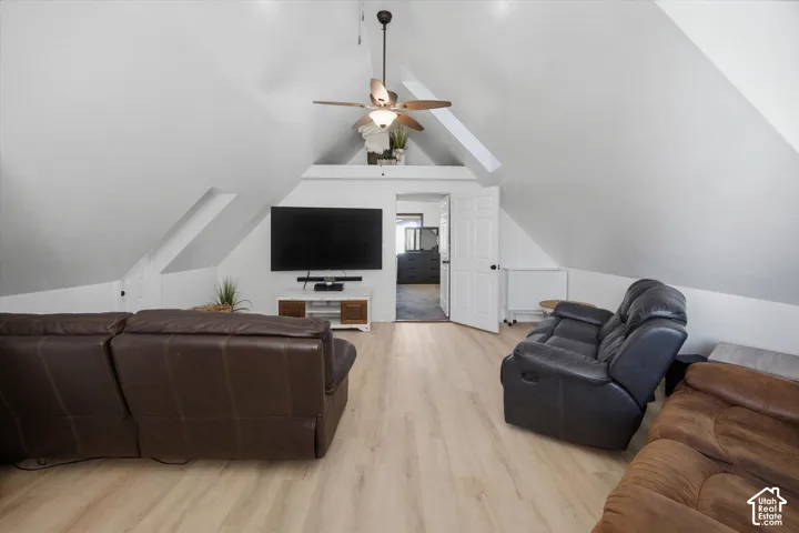 Vaulted ceilings, wood-finish flooring, ceiling fan, white paneled door
