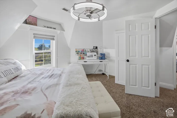 White paneled interior doors, textured carpet flooring, window with roller shade, and a contemporary ceiling fan with integrated lighting