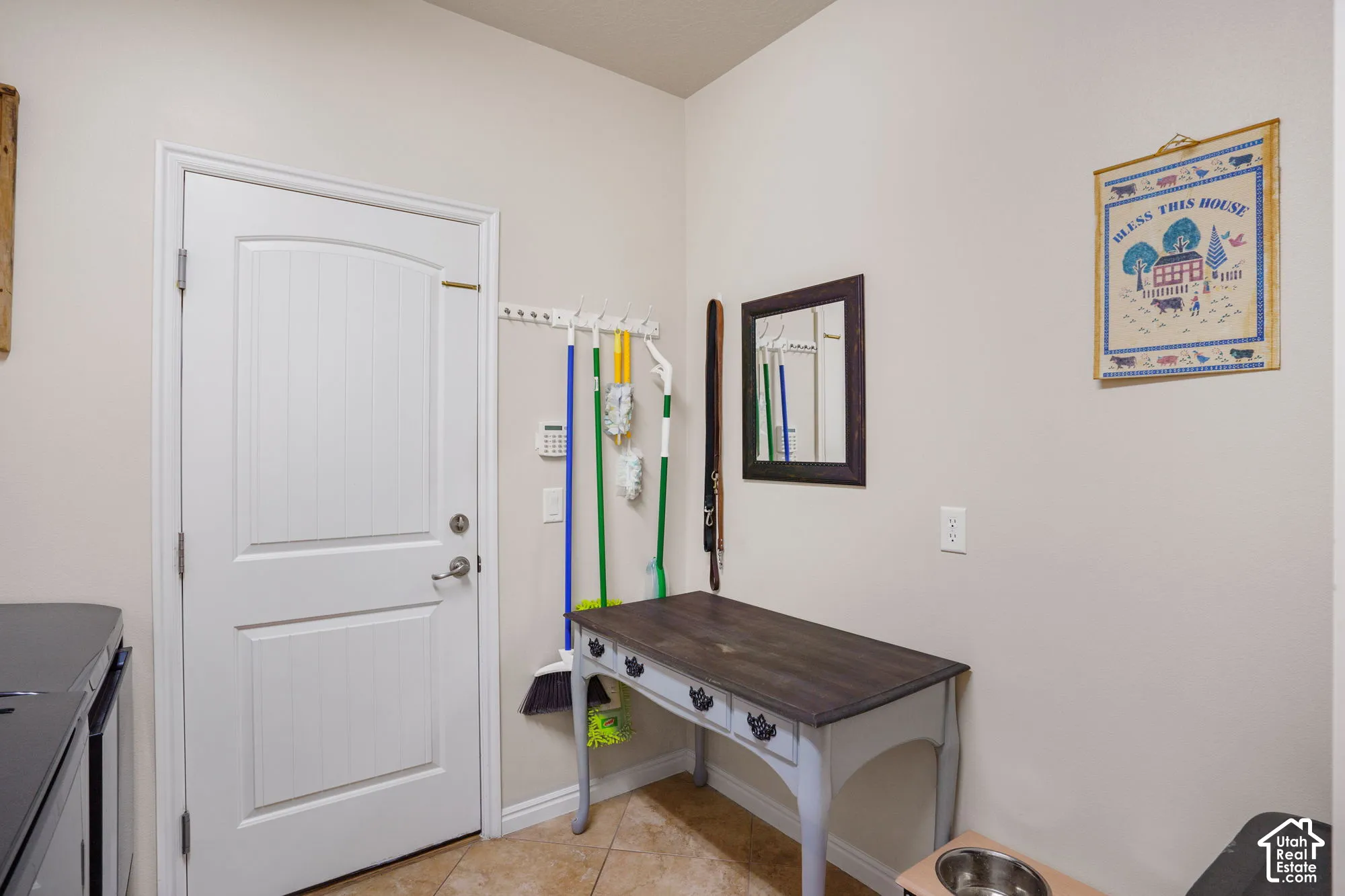 White paneled door with an arched top, tile flooring, and a wall-mounted hook rack