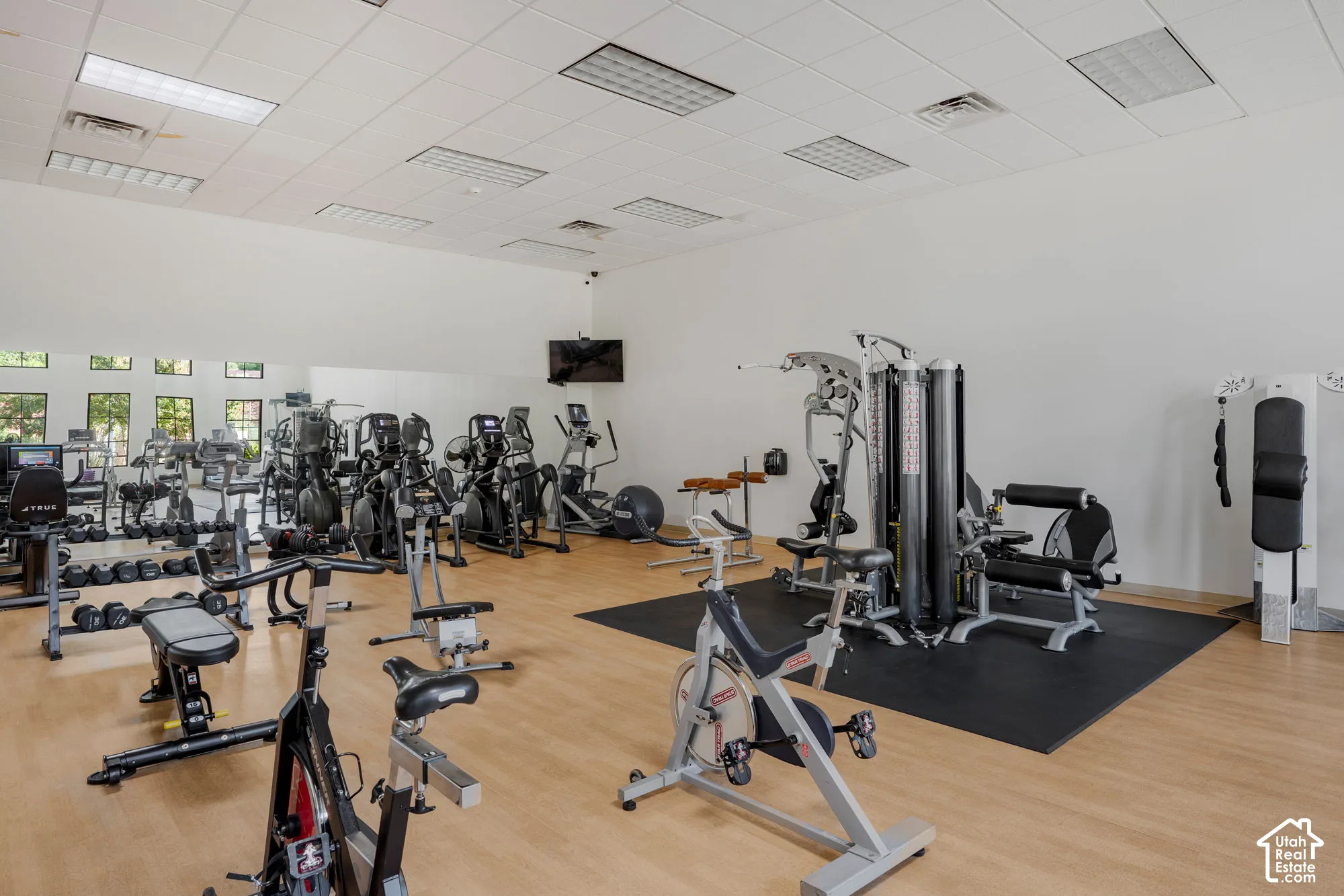 Spacious fitness center featuring wood-finish flooring, mirrored walls, and recessed lighting