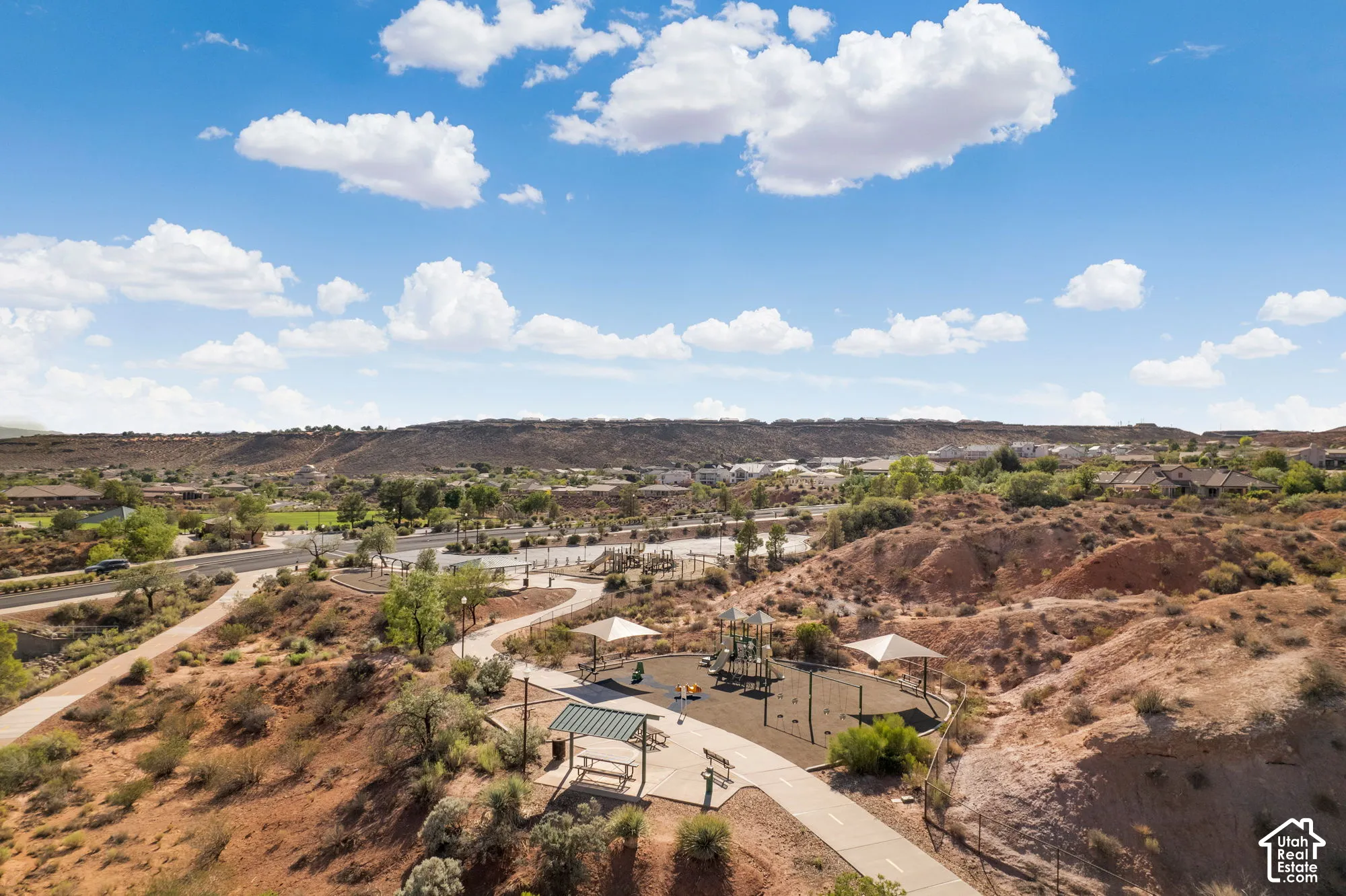 Community park with playground, covered picnic areas, paved walking paths, and arid landscaping