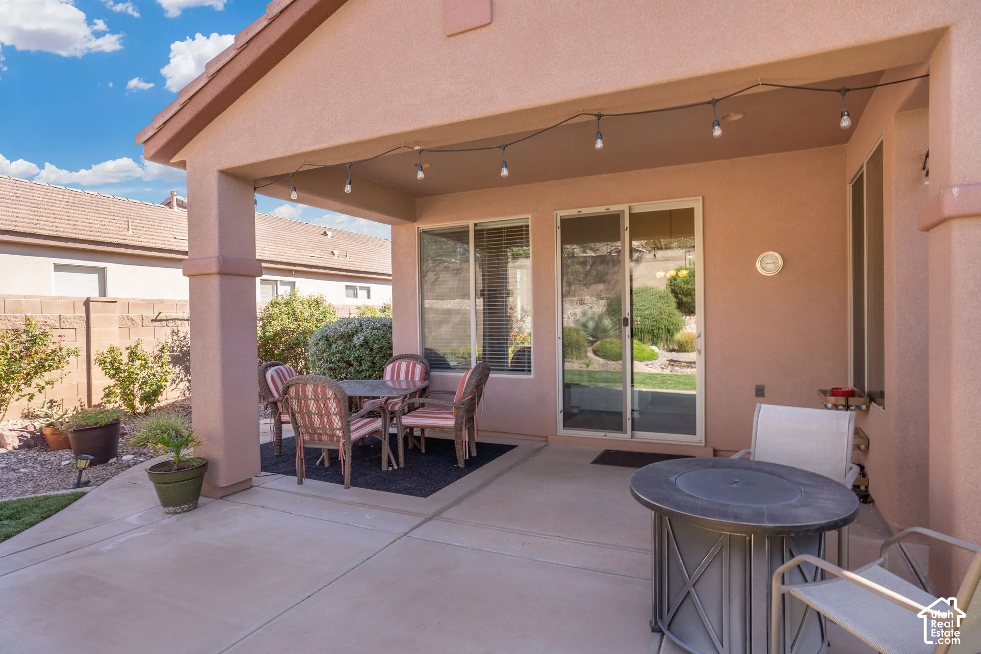 Covered patio with integrated lighting, concrete flooring, and sliding glass door access to the interior