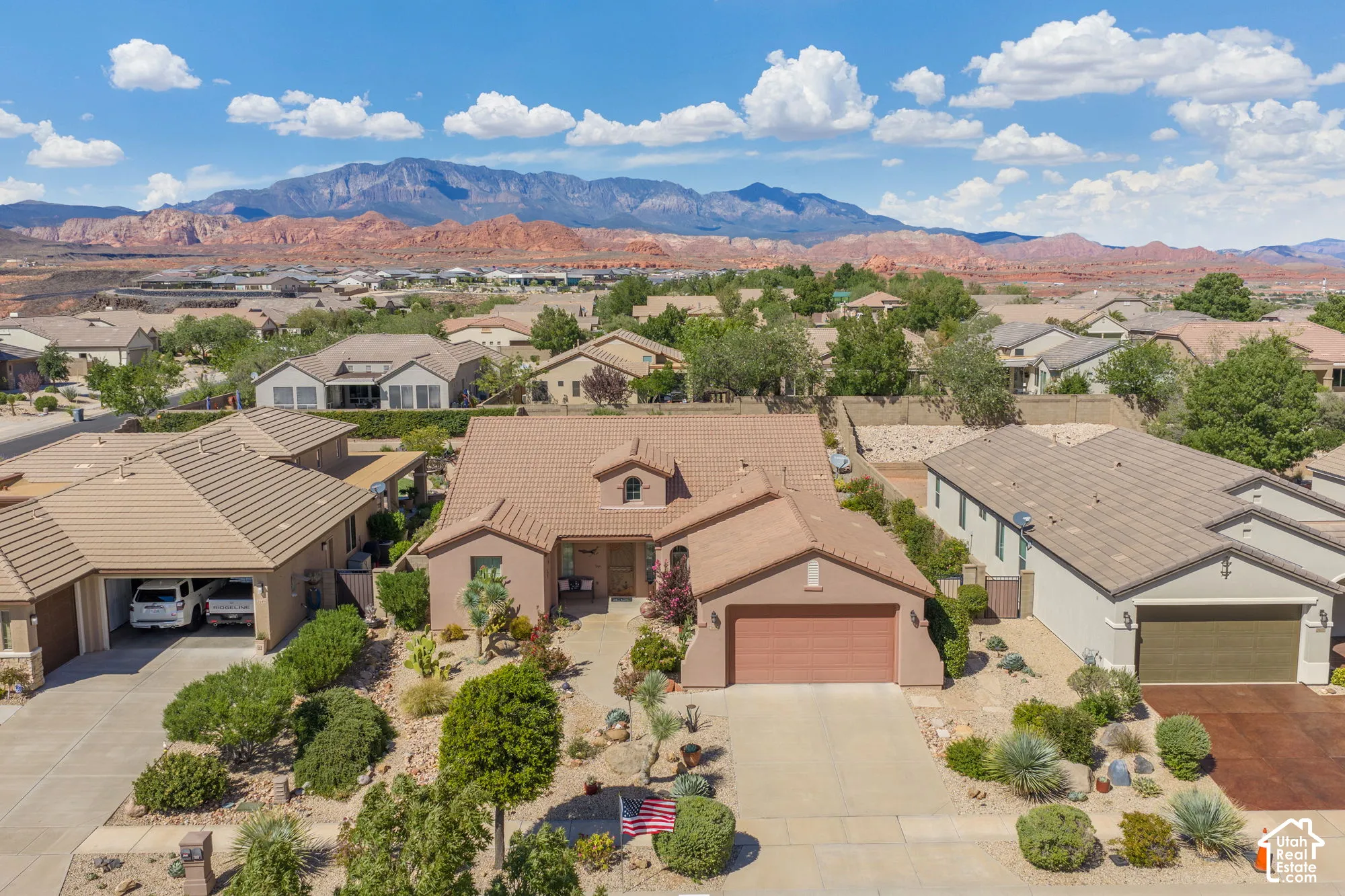 Terracotta roof tiles, stucco exterior, integrated garage, arid-adapted landscaping, and expansive mountain scenery