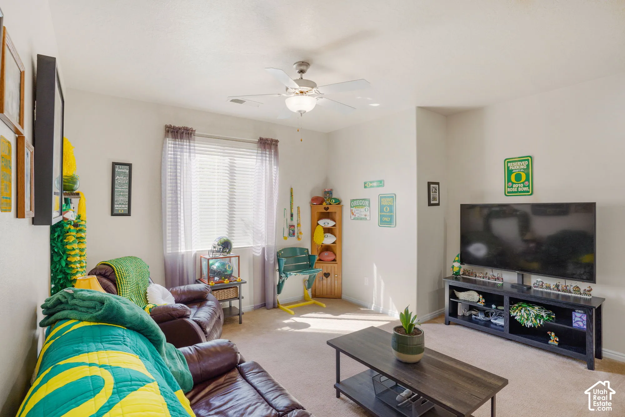 Recessed ceiling lighting and a ceiling fan fixture illuminate this space, which features light-toned carpeting and a window with blinds