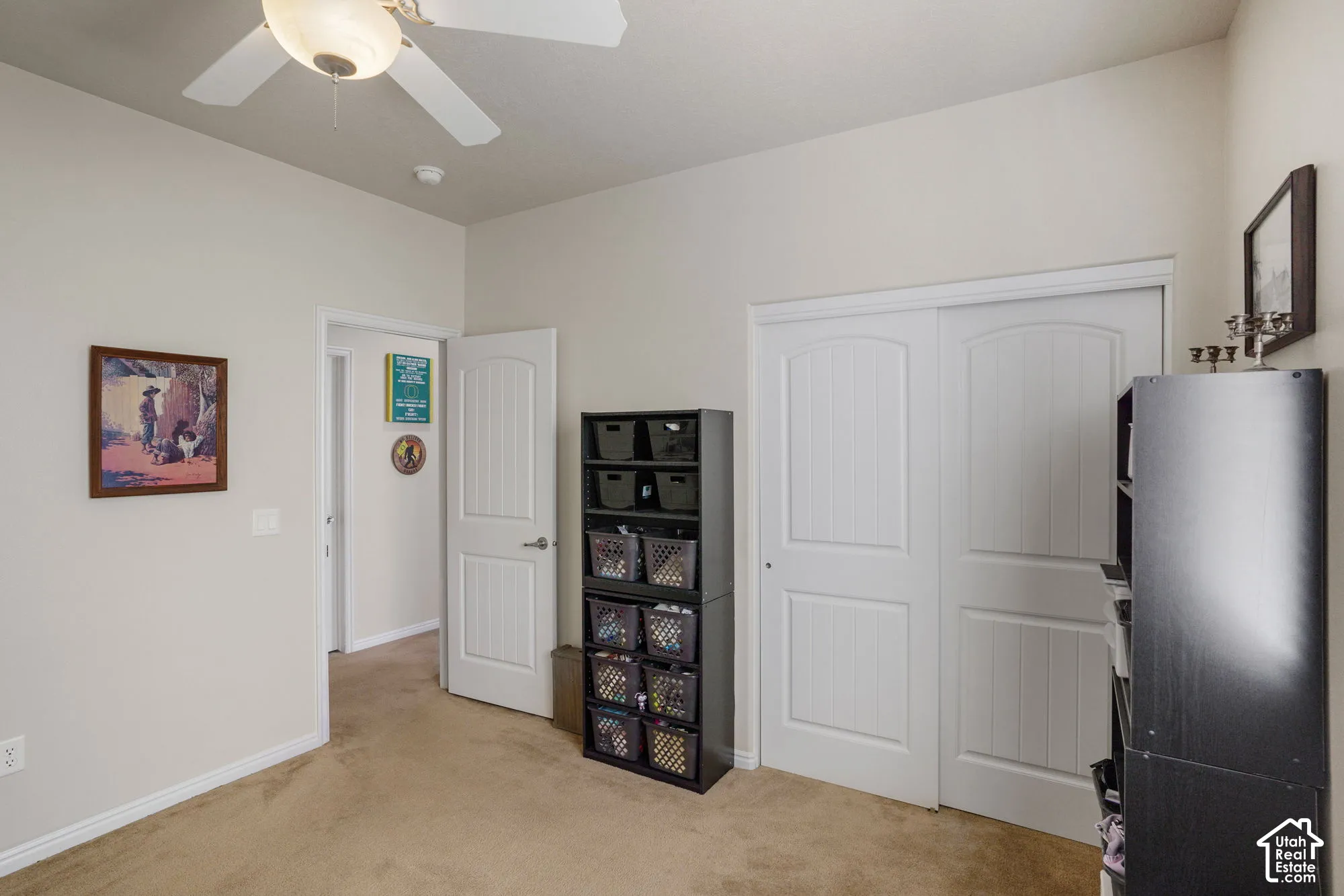 Ceiling fan with integrated lighting, two-panel interior doors, and carpet flooring