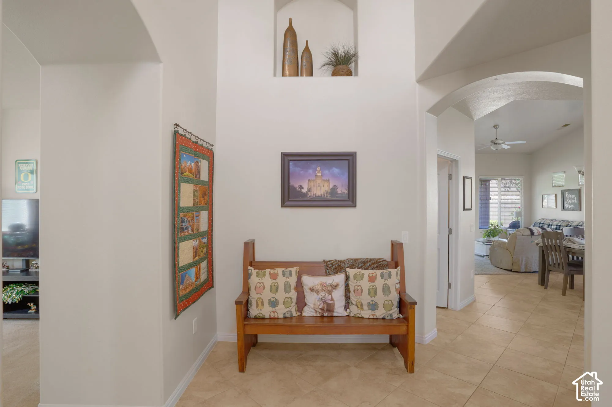Archway entry with tiled flooring, recessed wall niche, and vaulted ceiling
