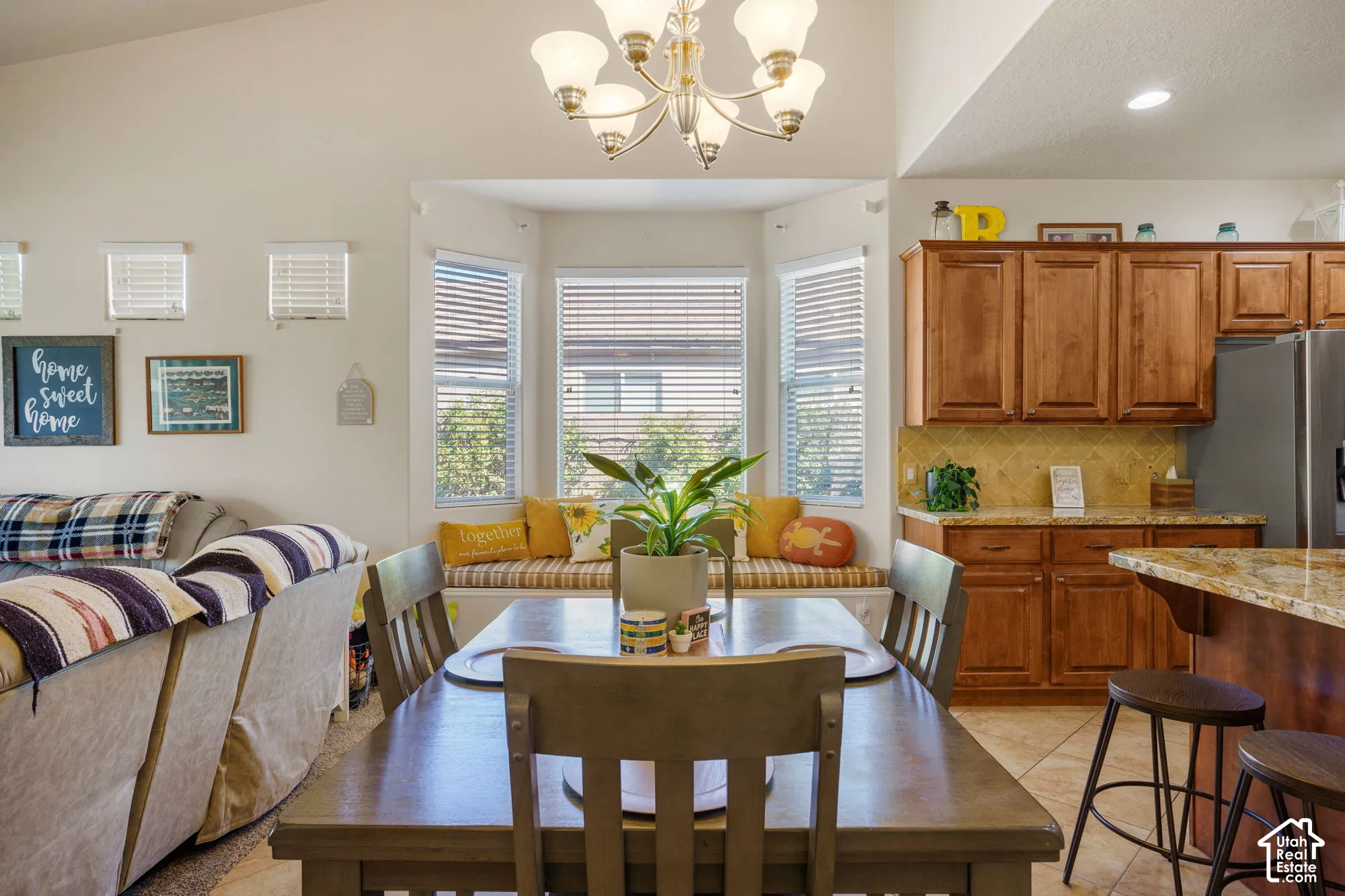 Dining area with an angular bay window and built-in window seating, accompanied by a wood-finish dining table and chairs