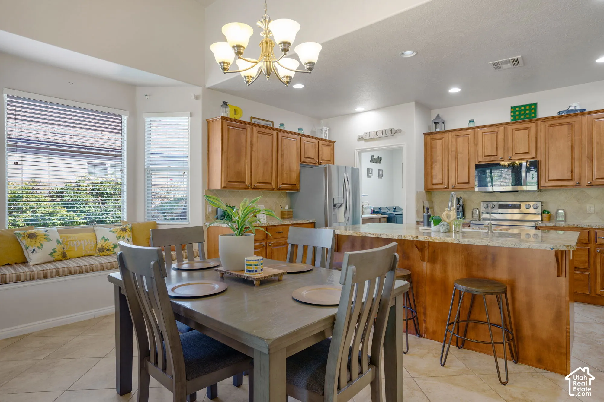 Spacious kitchen with wood cabinetry, light-toned countertop, and stainless steel appliances