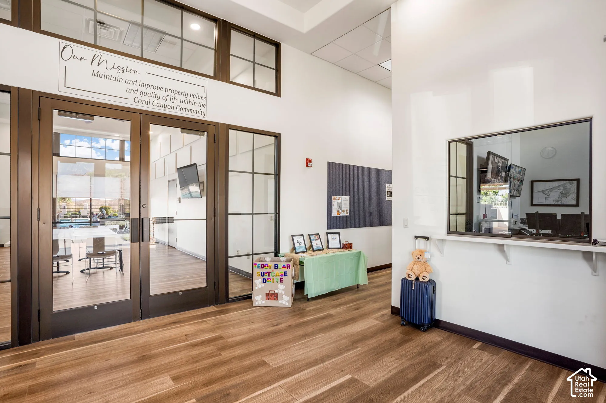 Wood-finish flooring, glass-paneled double doors, extensive glass transom windows, and a service window