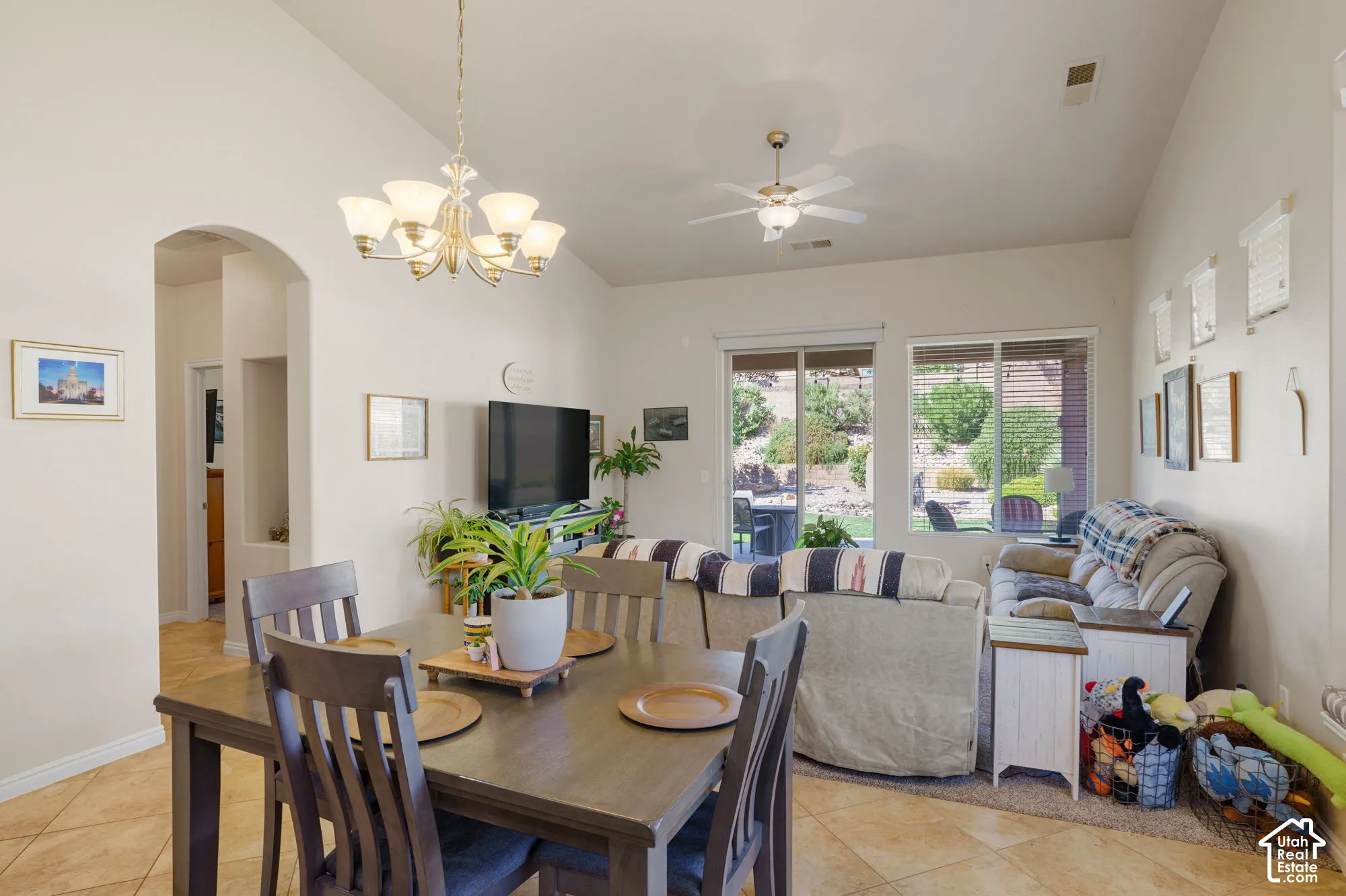 Vaulted ceilings with a ceiling fan, recessed lighting, and a brass-finish chandelier
