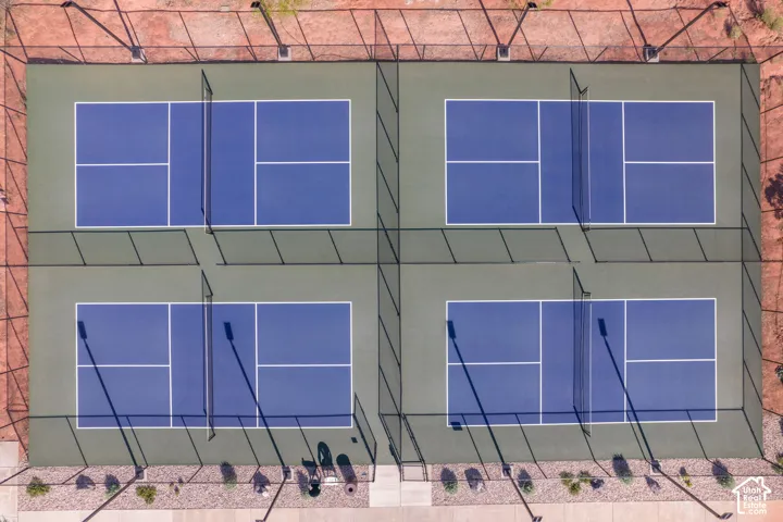 Four fenced pickleball courts with blue and green surfaces