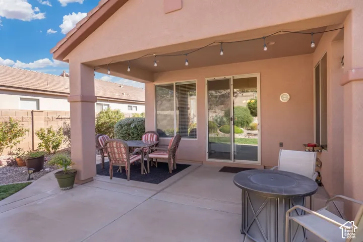 Covered patio with integrated lighting, concrete flooring, and sliding glass door access to the interior