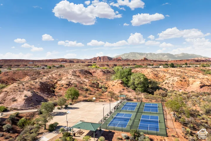 Four pickleball courts, a basketball court, and a covered picnic area set against a desert landscape with distant mountains