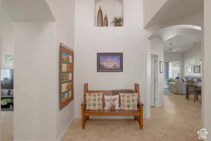 Archway entry with tiled flooring, recessed wall niche, and vaulted ceiling