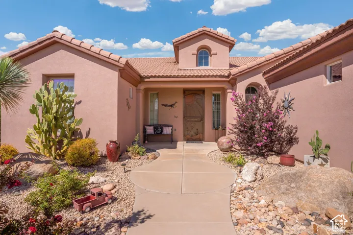 Southwestern-style architecture featuring a stucco exterior, tile roof, and arched windows