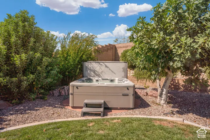 Relaxing spa with a partially open cover, surrounded by gravel landscaping