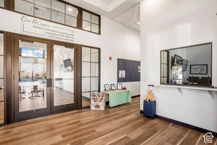 Wood-finish flooring, glass-paneled double doors, extensive glass transom windows, and a service window