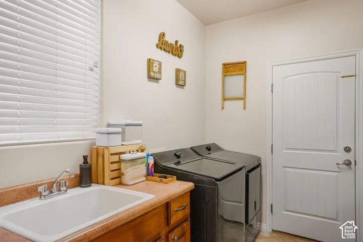 Utility room with a sink basin, counter space, and integrated cabinetry