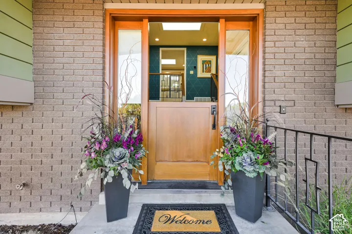 Beautiful Dutch door style entry door with sidelights, brick exterior, and a wrought iron handrail