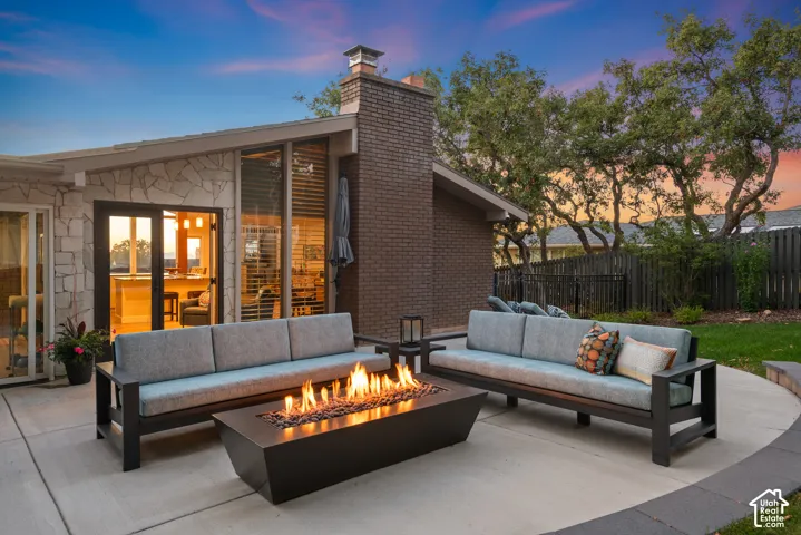 Easy flow from the French doors to expansive concrete patio featuring a built-in fire pit and mountain views