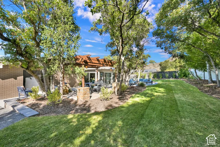 Expansive lawn with mature trees, garden boxes,  and a custom pergola with permanent lighting, mountain views!