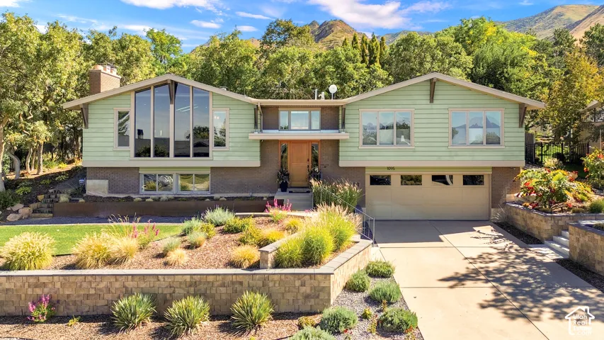 Split-level residence featuring a light green siding exterior