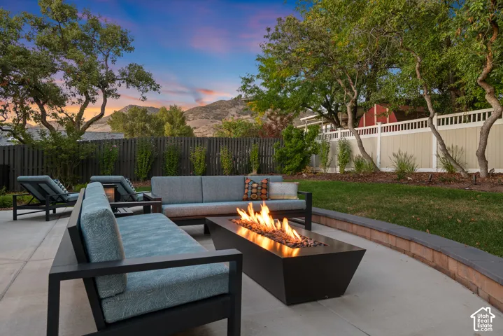 Private patio area featuring mountain views, a built-in fire pit, multiple seating areas, and professionally landscaped yard