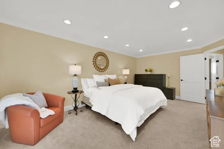 Recessed ceiling lighting, crown molding, light neutral wall tones, carpeted flooring, and a flat-panel interior door