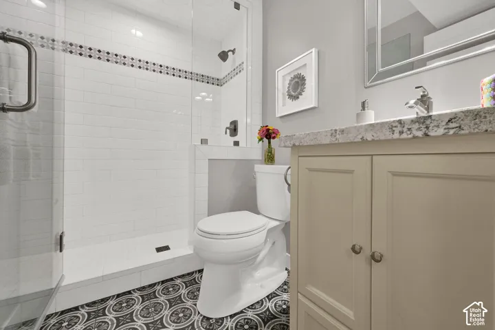 Frameless glass shower enclosure with subway tile surround and decorative accent band, complemented by a built-in shower niche