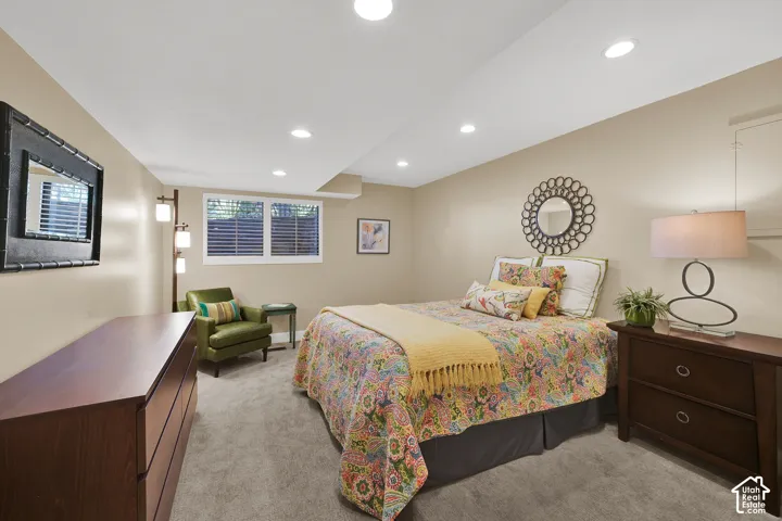 Lower level guest room with daylight window, Recessed ceiling lighting, carpeting, and a window with  plantation shutters
