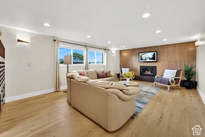 Spacious Lower Level Family room with gas fireplace, Recessed lighting, and daylight basement windows, beautiful  LVP flooring, and decorative wall sconces