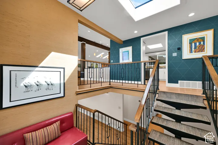 Staircase featuring custom iron handrails and black metal balusters and gate for pets or kiddos