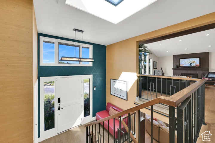 Bright Foyer with transom windows, skylight, and a contemporary linear pendant light