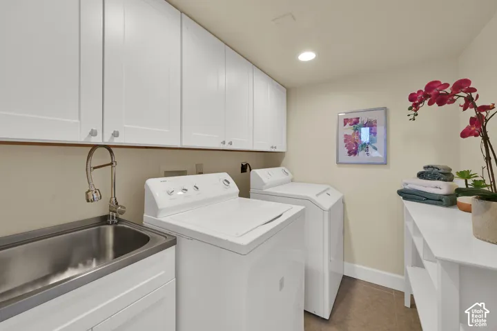 Utility area featuring white shaker-style cabinetry, a stainless steel sink with a gooseneck faucet, and integrated overhead lighting