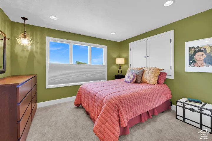 Recessed lighting, triple window with cellular shade, built-in closet, and carpet flooring